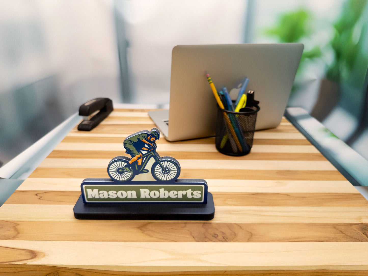 Mountain biker desk sign with the name Mason Roberts, front view on a wooden desk.