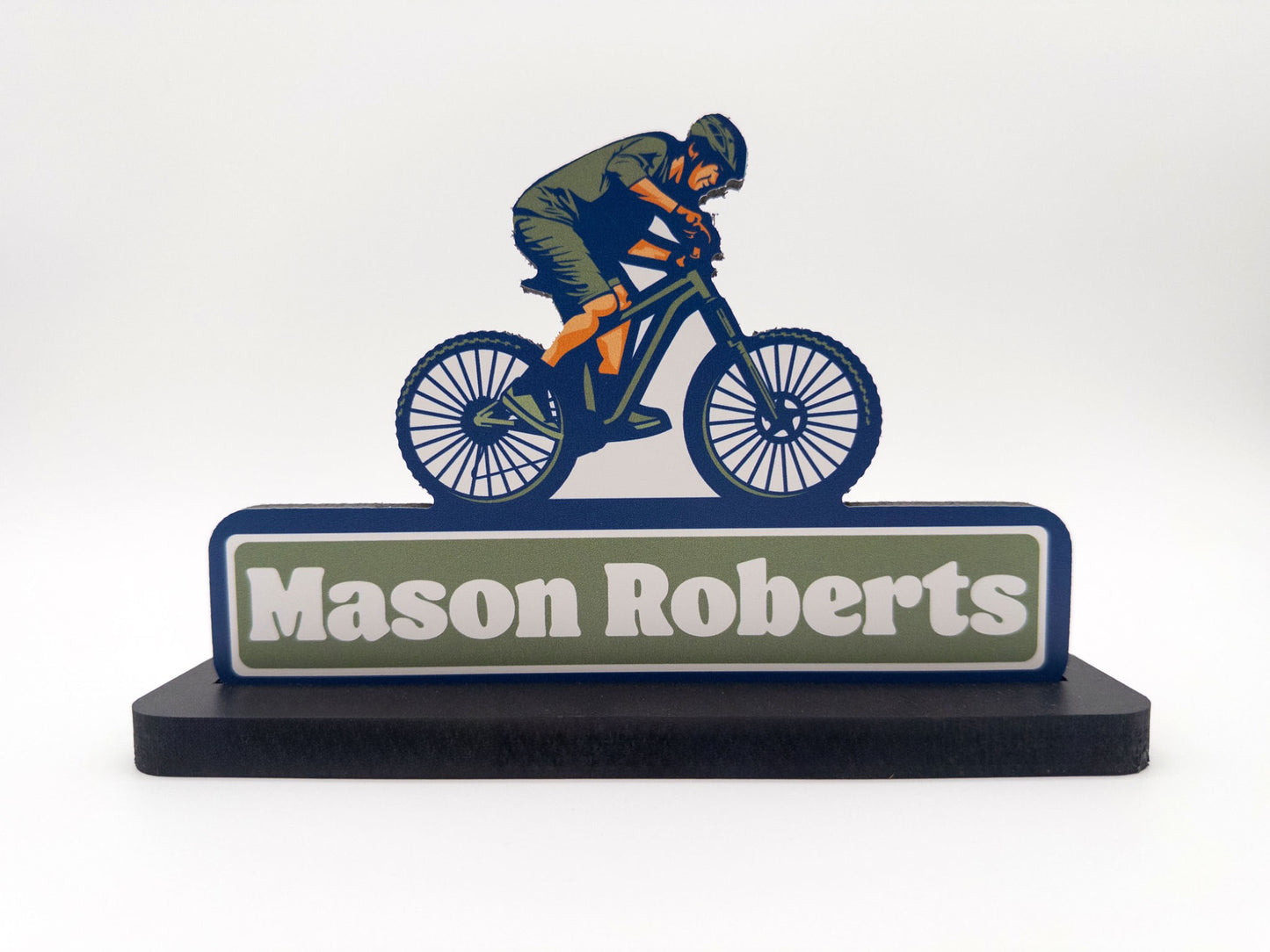 Closeup view of mountain biker desk sign with the name Mason Roberts against a white background.