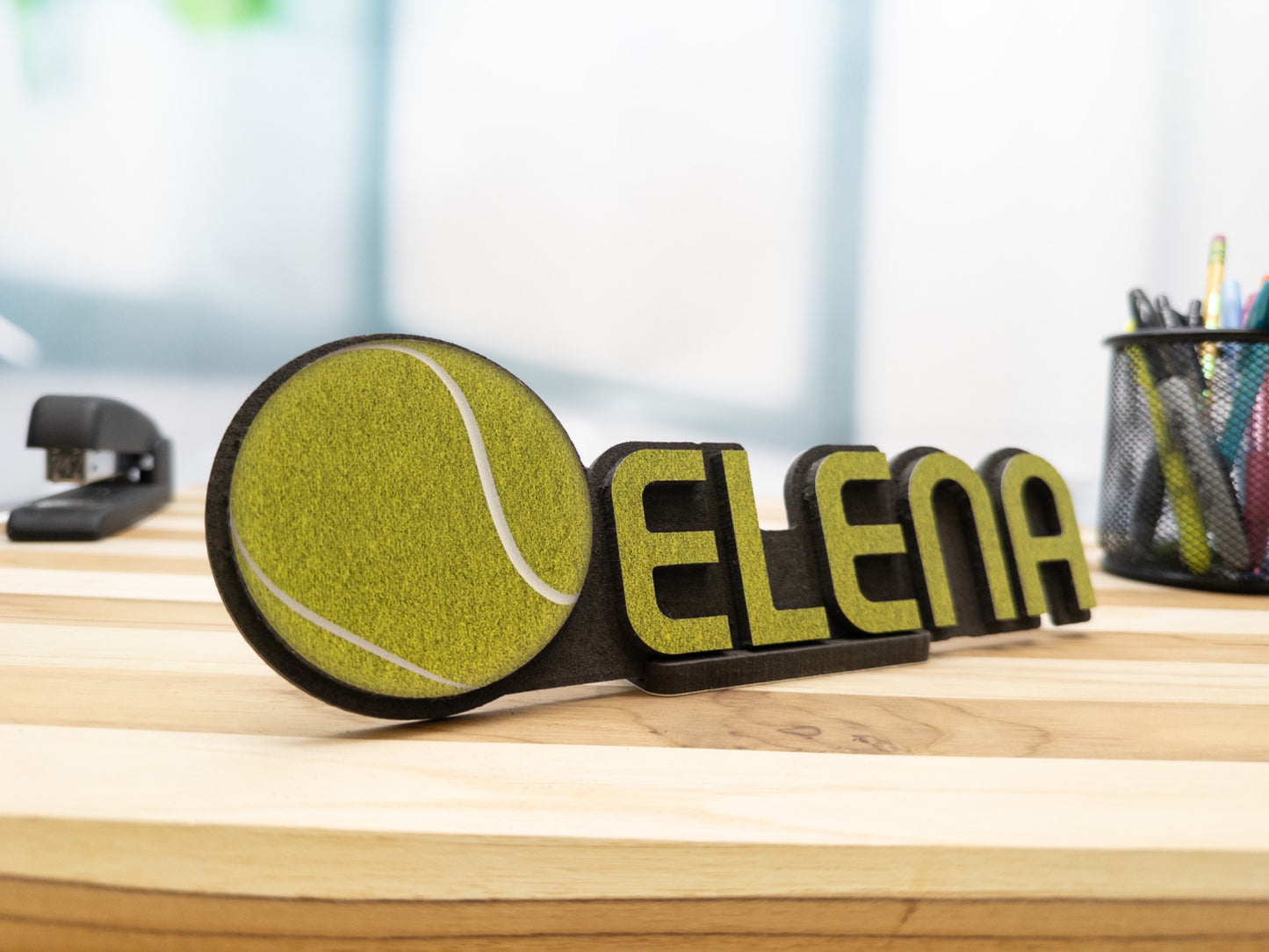 Close-up view of a custom desk name plate with the name 'Elena' and a tennis ball graphic, perfect for highlighting its sporty design.