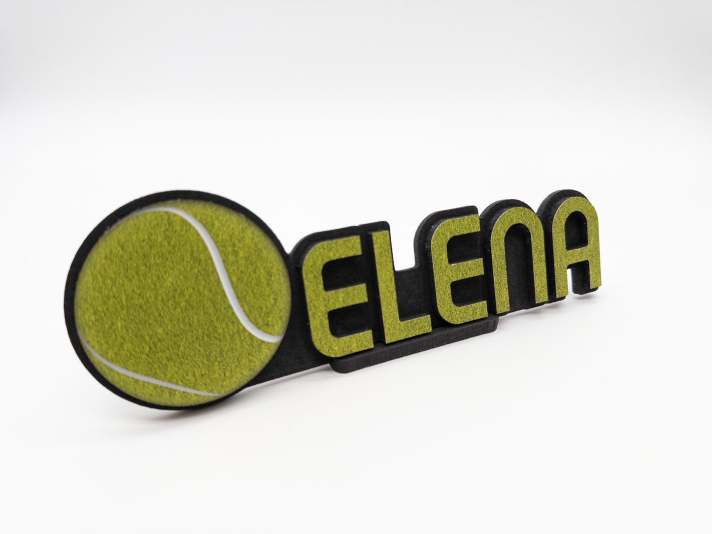 Angled view of a custom desk name plate featuring the name 'Elena' with a tennis ball graphic, highlighting the stylish and sporty design.