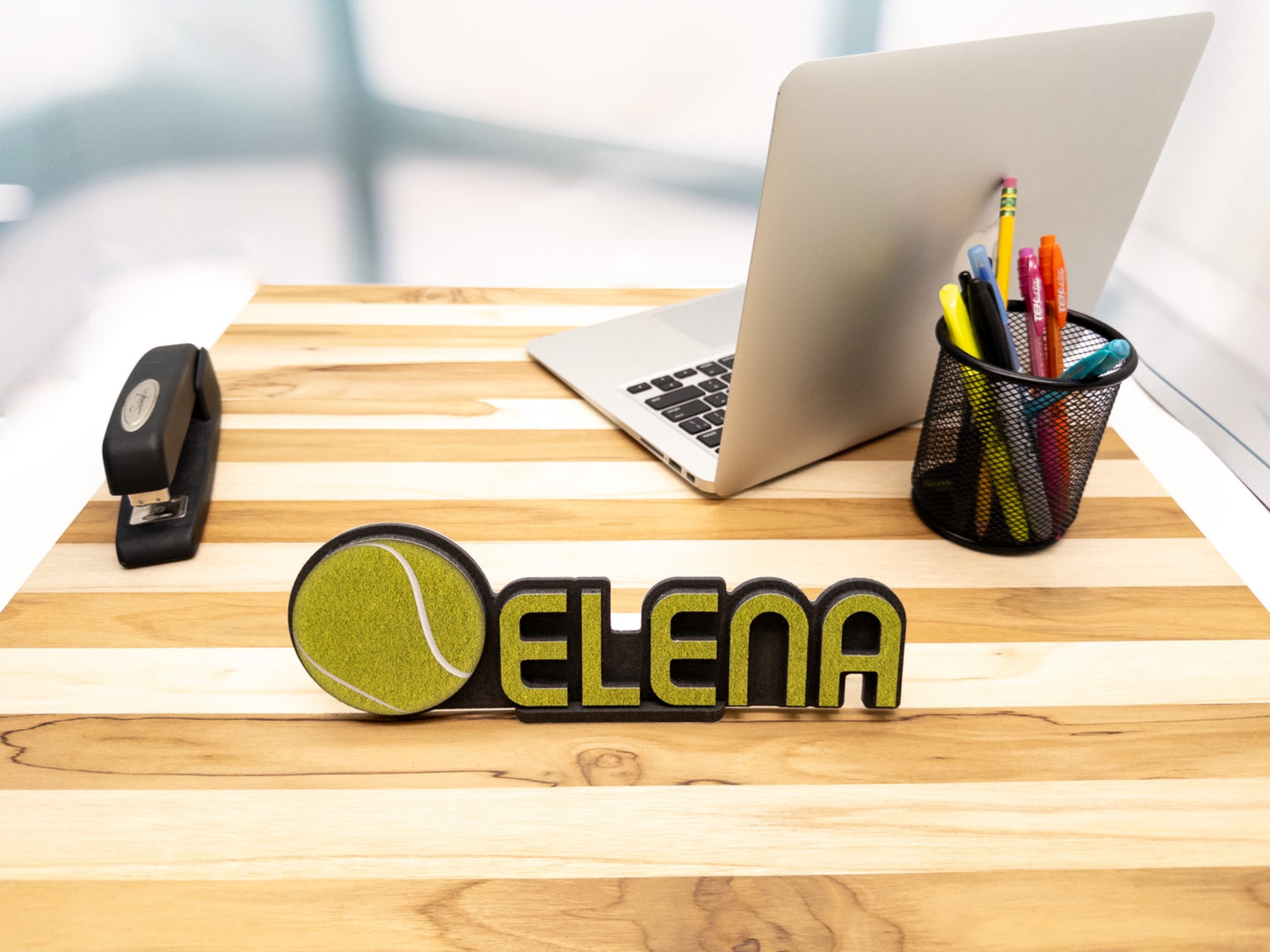 Close-up view of a custom desk name plate with the name 'Elena' and a tennis ball graphic, perfect for highlighting its sporty design.