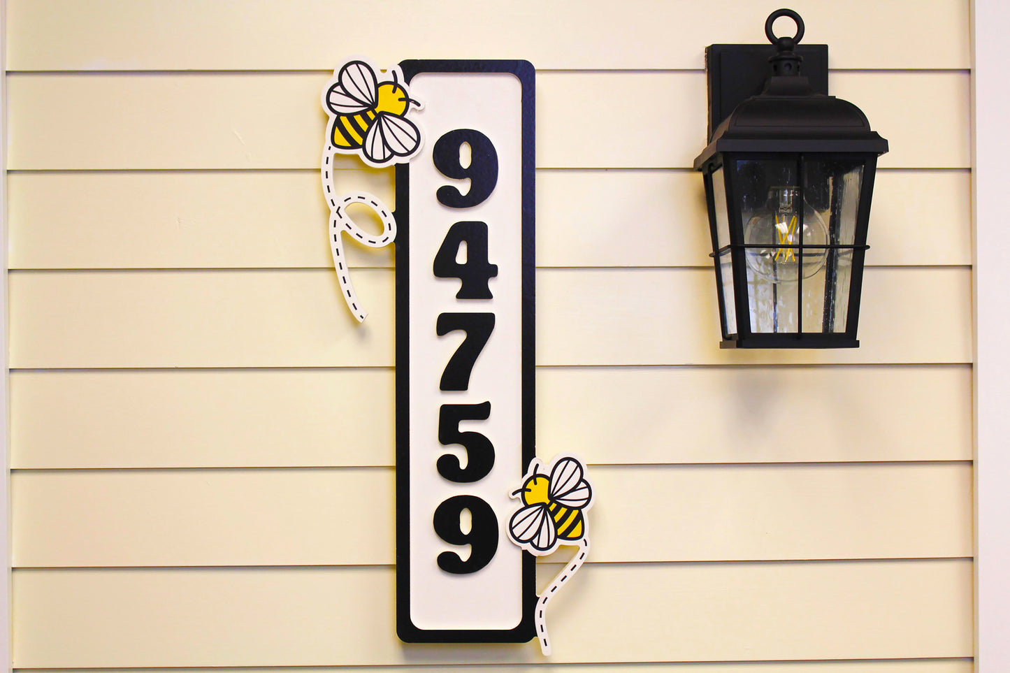 Front view close-up of the house number sign with bee decorations.