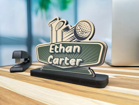 Desk name plate for Ethan Carter featuring golf-themed icons, including a golf club and ball, displayed on a wooden desk.