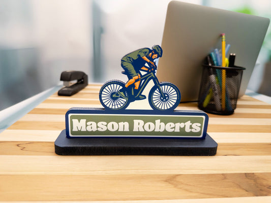 Mountain biker desk sign with the name Mason Roberts, front view on an office desk.