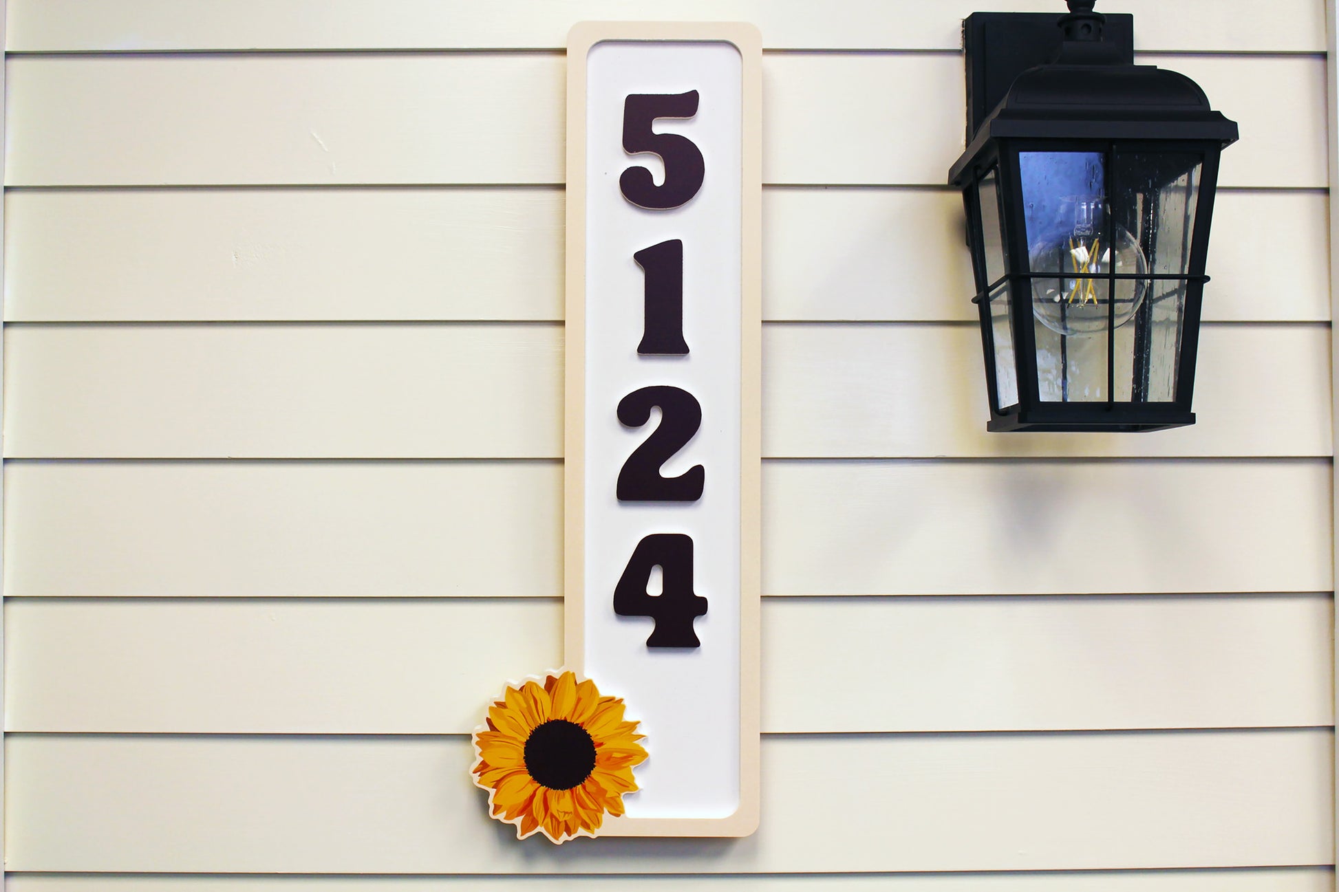 Front close-up view of house numbers sign featuring a sunflower design.