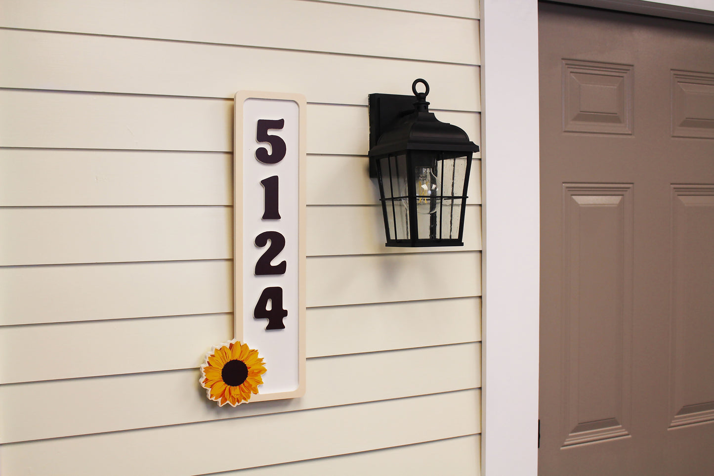 Side angle view of house numbers plaque with sunflower.