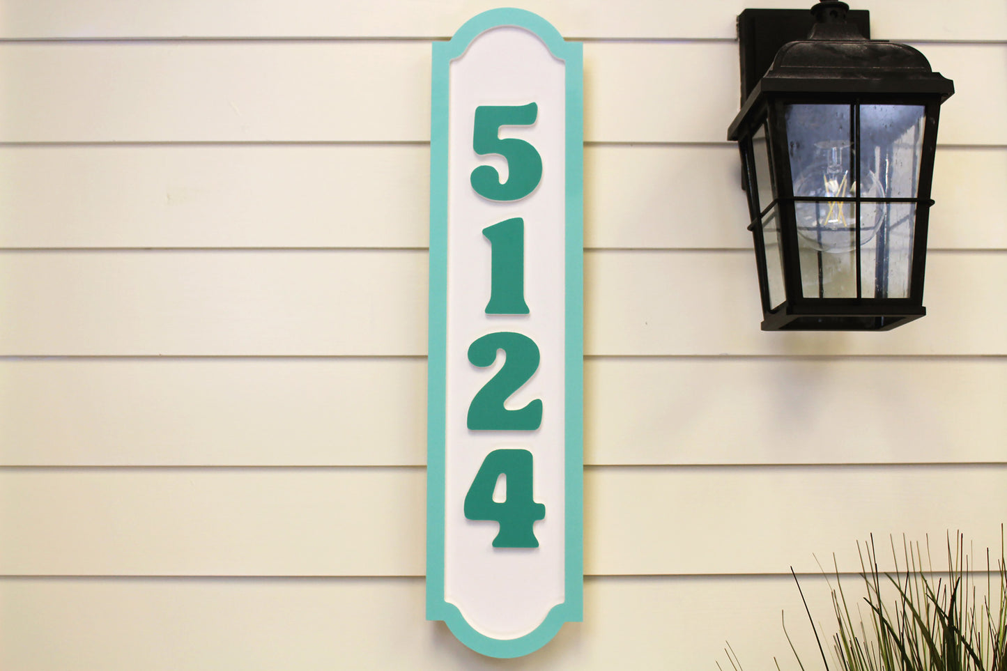 Vertical house number sign with teal border and the number "5124.